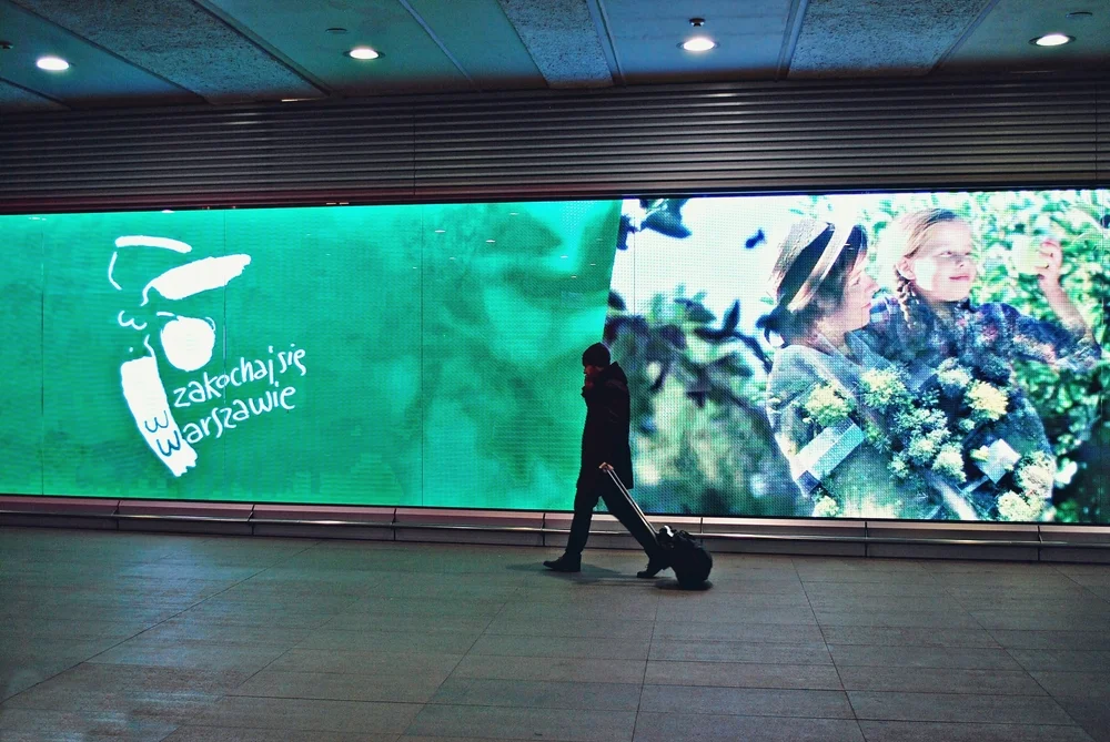 woman walking in front of led advertising screen